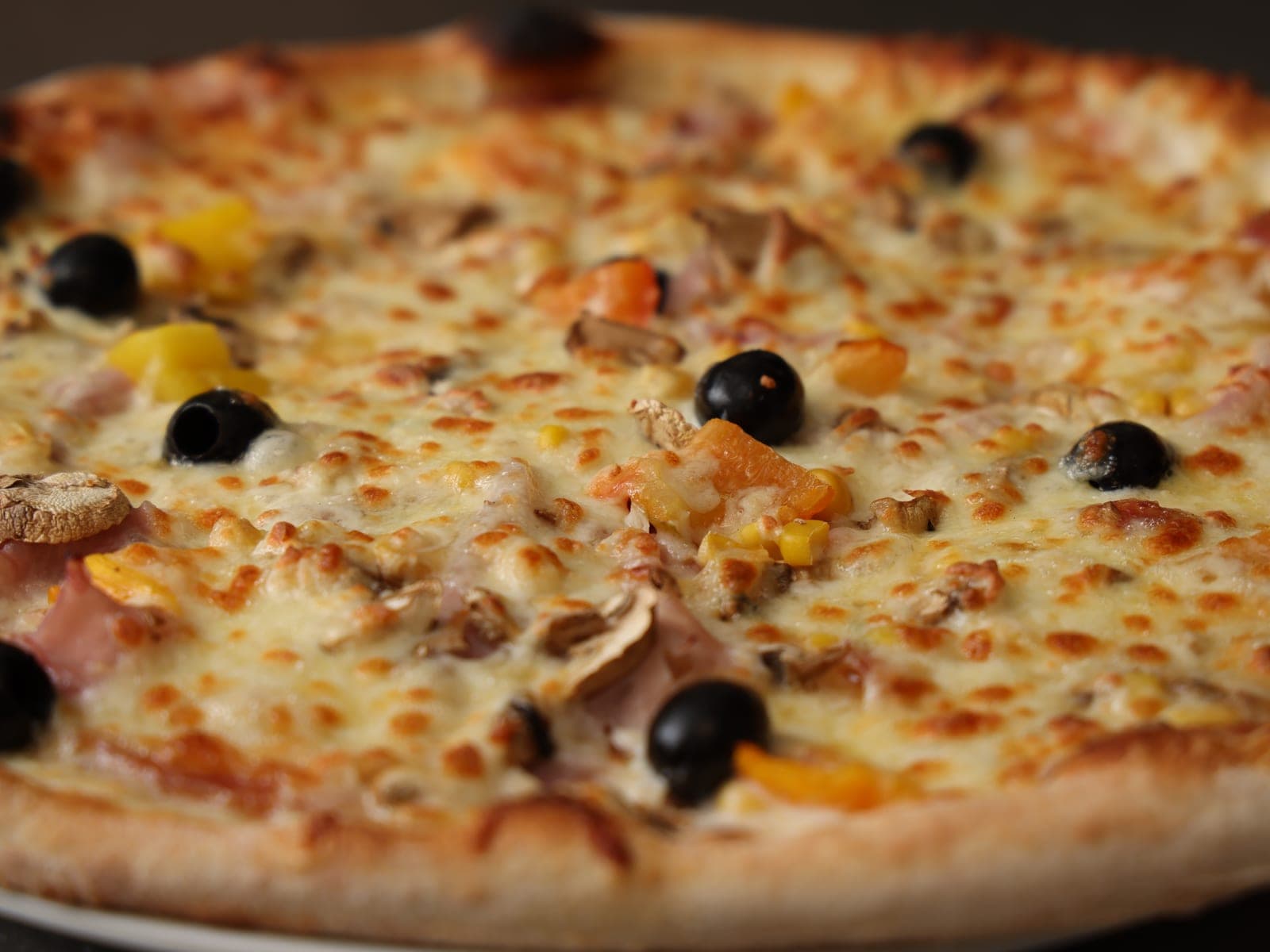 Ofenfrische Pizza mit Schinken und Oliven